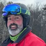 Mike Reilly, Co Founder of Challenge Accepted, stops to smile during a snowboarding trip